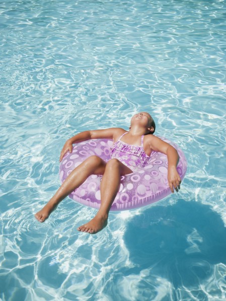Girl (8-9) floating on rubber ring.