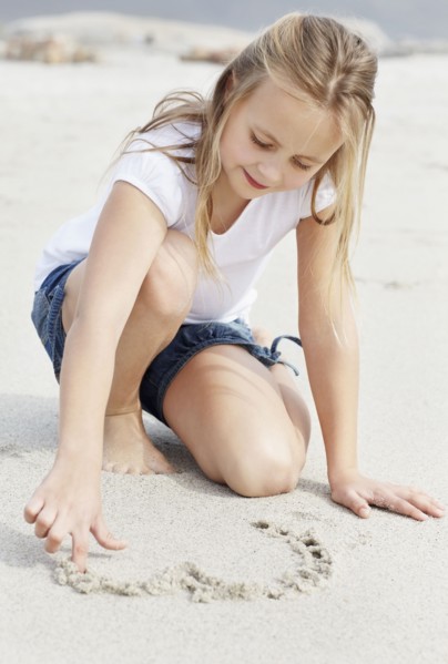 Girl (10-11) playing on beach. Photo : Momentimages