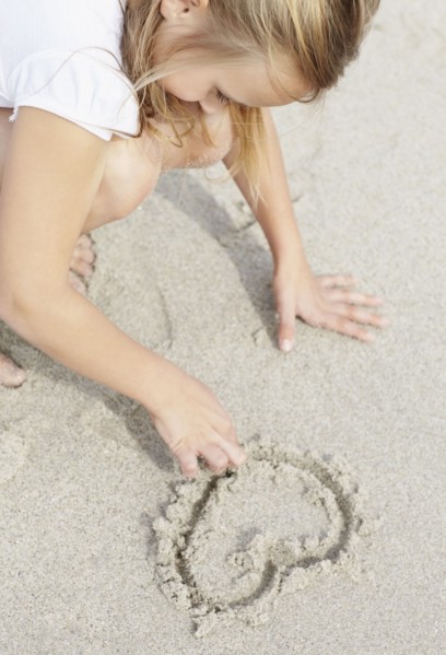 Girl (10-11) playing on beach. Photo : Momentimages