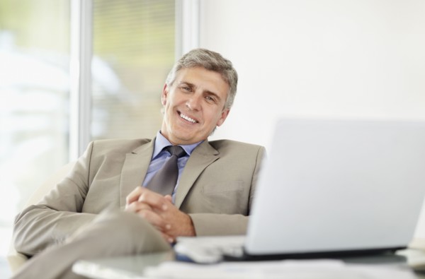 Portrait of cheerful businessman with laptop. Photo : Momentimages