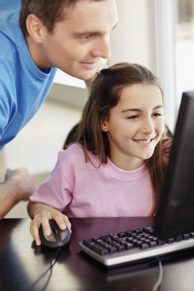Father with daughter (10-11) playing with computer. Photo : Momentimages
