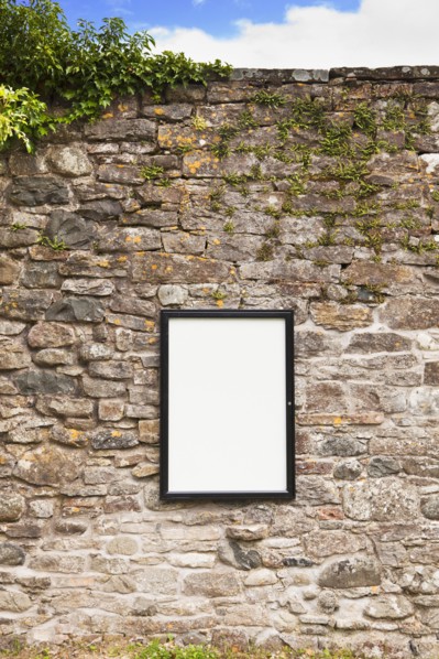 Blank sign on stone wall . Photo : Jon Boyes