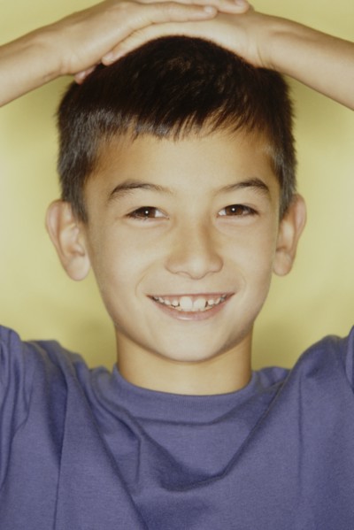 Cute young boy with his hands on his head. Photo : Fisher Litwin