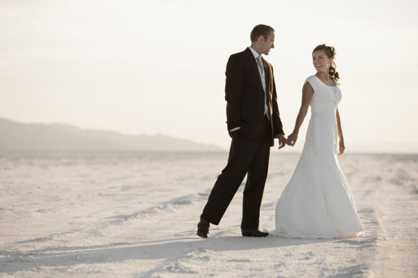 Bride and groom holding hands in desert. Photo : FBP