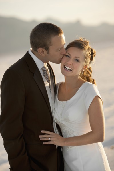 Groom kissing bride in desert. Photo : FBP