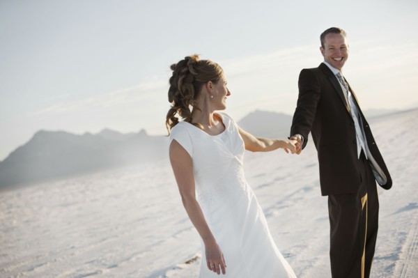 Bride and groom holding hands in desert. Photo : FBP