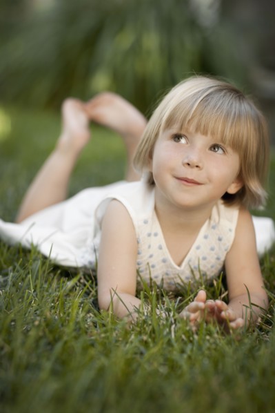 Girl (2-3) lying on grass. Photo : FBP
