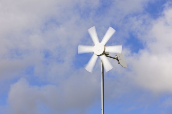 Old wind turbine against cloudy sky. Photo : Jon Boyes
