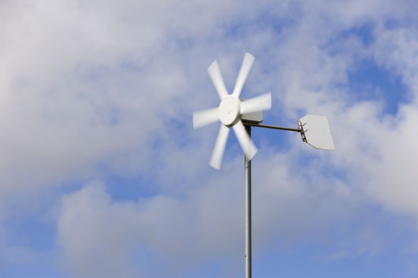 Old wind turbine against cloudy sky. Photo : Jon Boyes