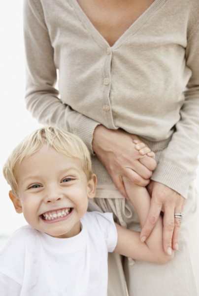 Portrait of boy (4-5) holding mother hand and making face. Photo : Momentimages