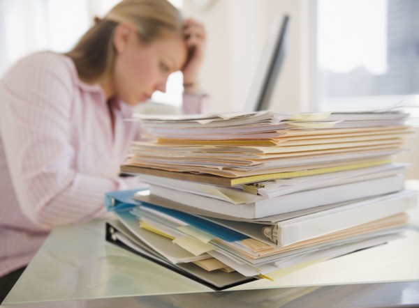USA, New Jersey, Jersey City, Stressed young businesswoman doing paperwork. Photo : Jamie Grill