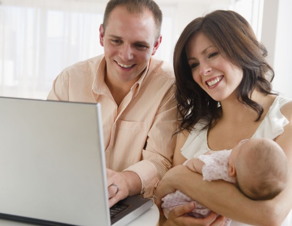 USA, New Jersey, Jersey City, family with baby daughter (2-5 months) sitting in front of laptop.