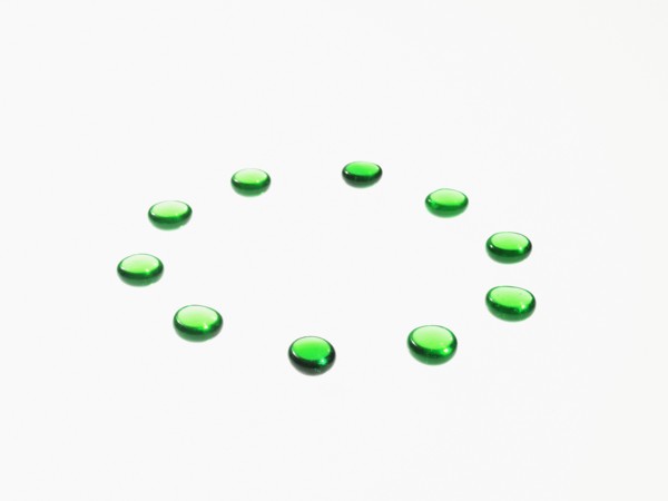 Studio shot of green glass beads in circle. Photo : David Arky