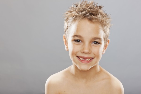 Studio portrait of toothless boy (8-9) smiling. Photo : FBP