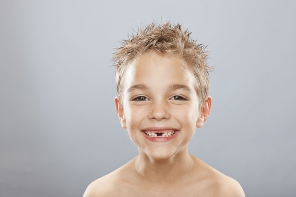 Studio portrait of toothless boy (8-9) smiling. Photo : FBP