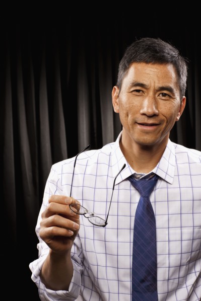 USA, Utah, Provo, Portrait of businessman standing in front of black curtain. Photo : FBP