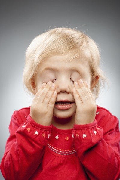 Portrait of girl (2-3) with hands covering eyes, studio shot. Photo : FBP