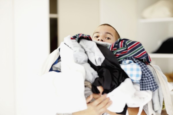 South Africa, Man standing with pile of laundry. Photo : momentimages
