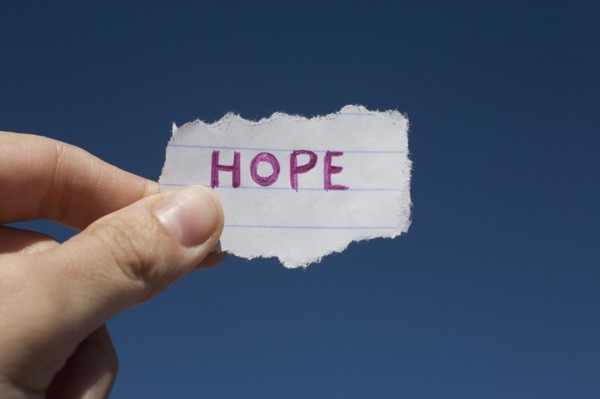 USA, Arizona, Winslow, Human hand holding paper with "hope" text on it. Photo : David Engelhardt