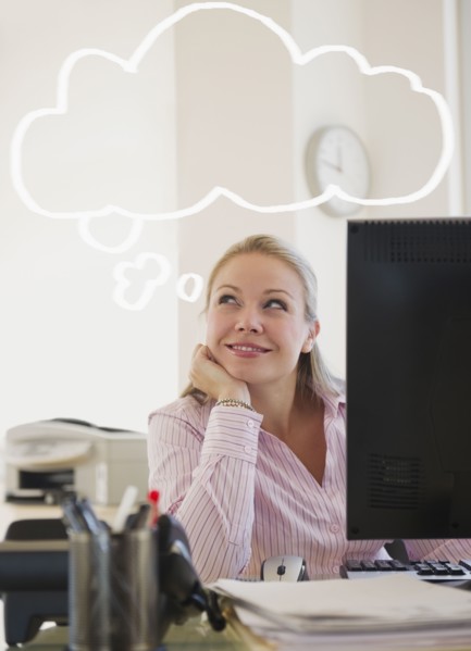 USA, New Jersey, Jersey City, Young attractive businesswoman daydreaming in office. Photo : Jamie