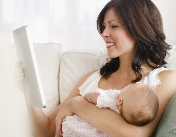 USA, New Jersey, Jersey City, Mother holding baby daughter (2-5 months), reading letter. Photo :