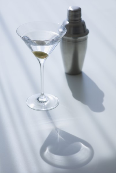Cocktail shaker and cocktail in glass.