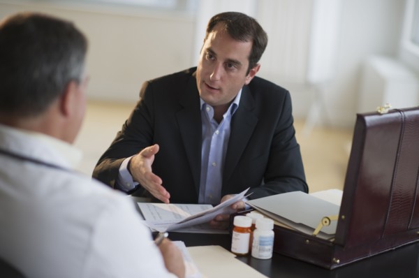 USA, New Jersey, Jersey City, Medical sales representative talking with doctor in office.