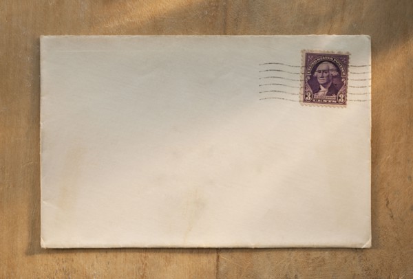 Blank envelope on wooden table.