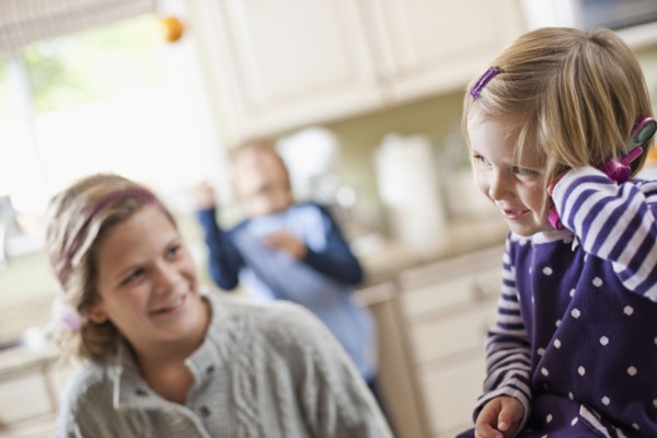 USA, Utah, Two girls (2-3, 10-11) in kitchen. Photo : Tim Pannell