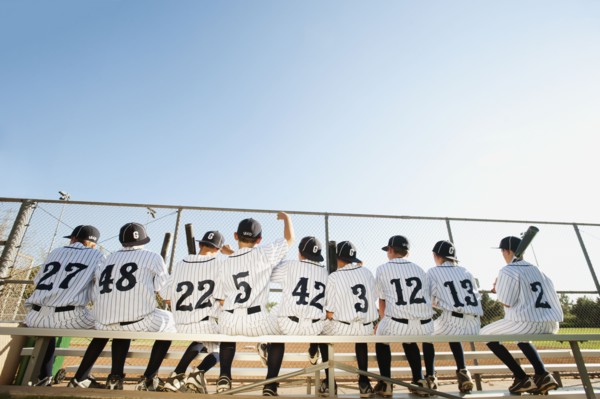 USA, California, Ladera Ranch, Boys (10-11) from little league sitting on bench, rear view.