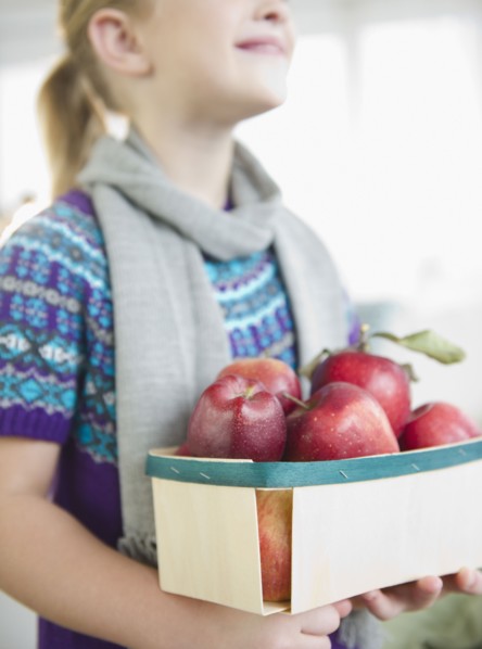 USA, New Jersey, Jersey City, Girl (8-9) holding box of apples. Photo : Jamie Grill Photography