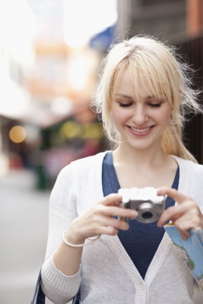 USA, Seattle, Smiling young woman holding digital camera. Photo : Take A Pix Media