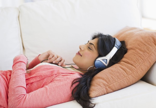 USA, New Jersey, Jersey City, Young attractive woman laying on back listening to music. Photo :