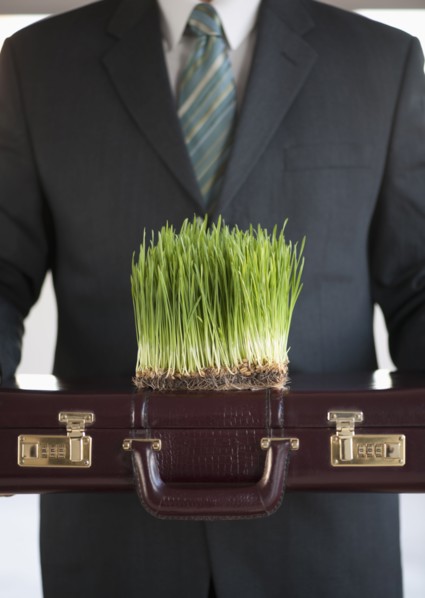 USA, New Jersey, Jersey City, Man holding growing grass in front of him.