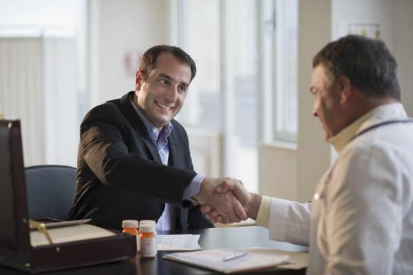 USA, New Jersey, Jersey City, Medical sales representative shaking hands with doctor in office.