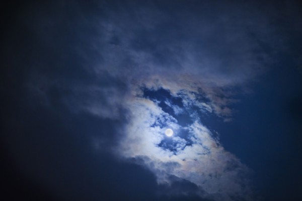 Full moon in cloudy sky at night.