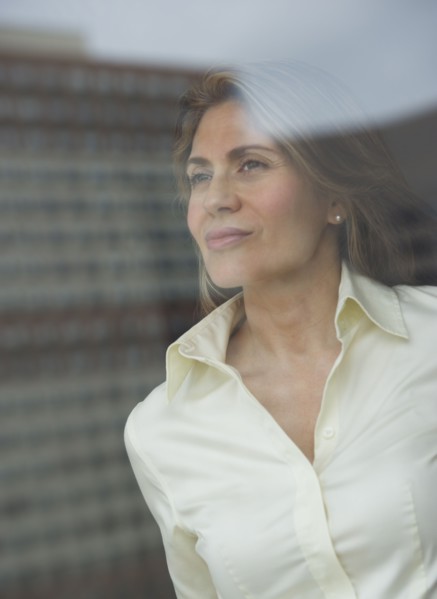 USA, New Jersey, Jersey City, Businesswoman looking through window.