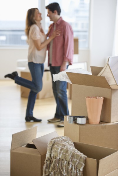 USA, New Jersey, Jersey City, Couple embracing near boxes in new home.