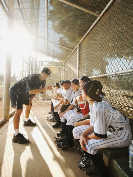 USA, California, Ladera Ranch, Boys (10-11) from little league sitting on dugout while coach