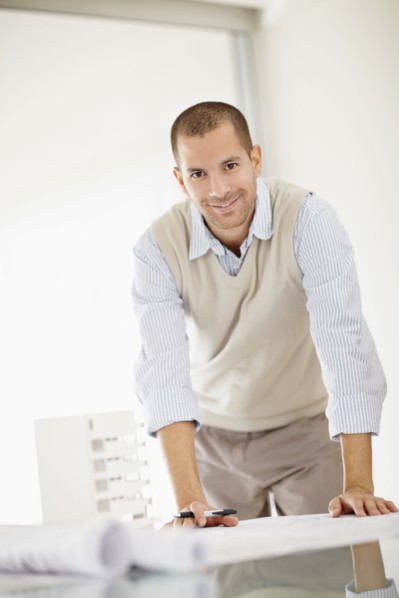 South Africa, Smiling architect working in office, portrait. Photo : momentimages