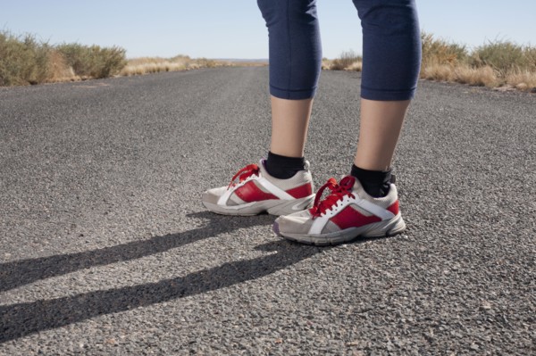 USA, Arizona, Winslow, Mid adult woman wearing spots shoes standing, low section. Photo : David