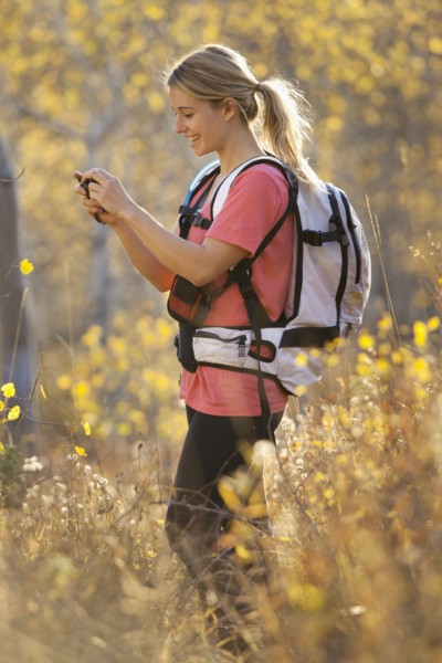 USA, Utah, young woman taking photograph in forest. Photo : Mike Kemp