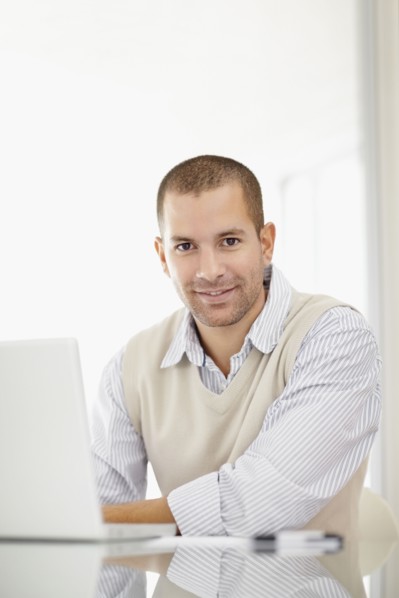 South Africa, Portrait of young man with laptop. Photo : momentimages