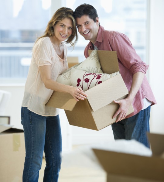 USA, New Jersey, Jersey City, Portrait of couple carrying box in new home.