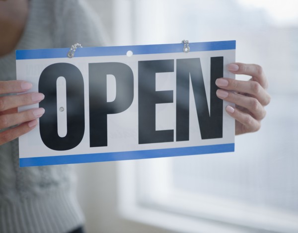 USA, New Jersey, Jersey City, Close-up view of woman holding open sign. Photo : Jamie Grill
