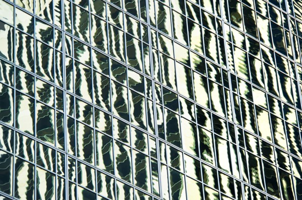 USA, New York, New York City, Reflections in windows of office block.