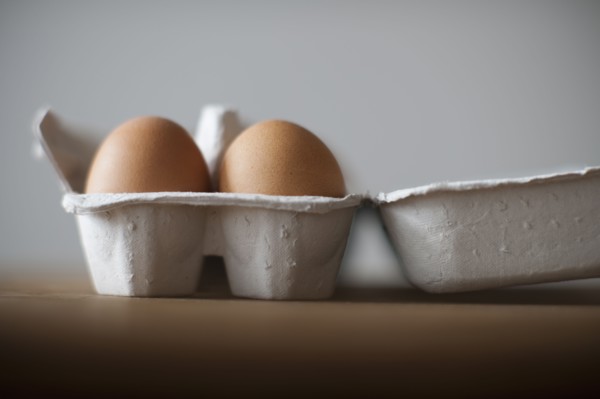 Eggs in egg carton on table, close-up.