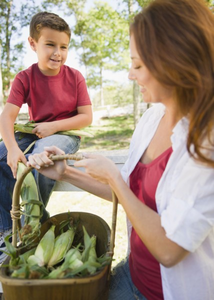 USA, New York, Flanders, Mother and son (8-9) with basket of corns. Photo : Jamie Grill Photography
