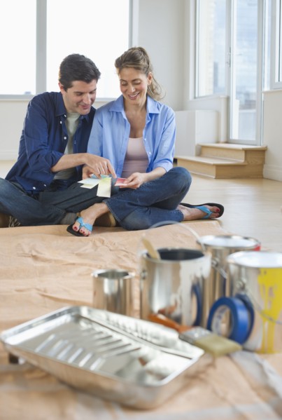 USA, New Jersey, Jersey City, Couple sitting near painting equipment in new home .