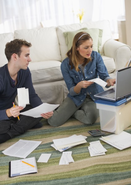 USA, New Jersey, Jersey City, Portrait of young couple doing paperwork at home.